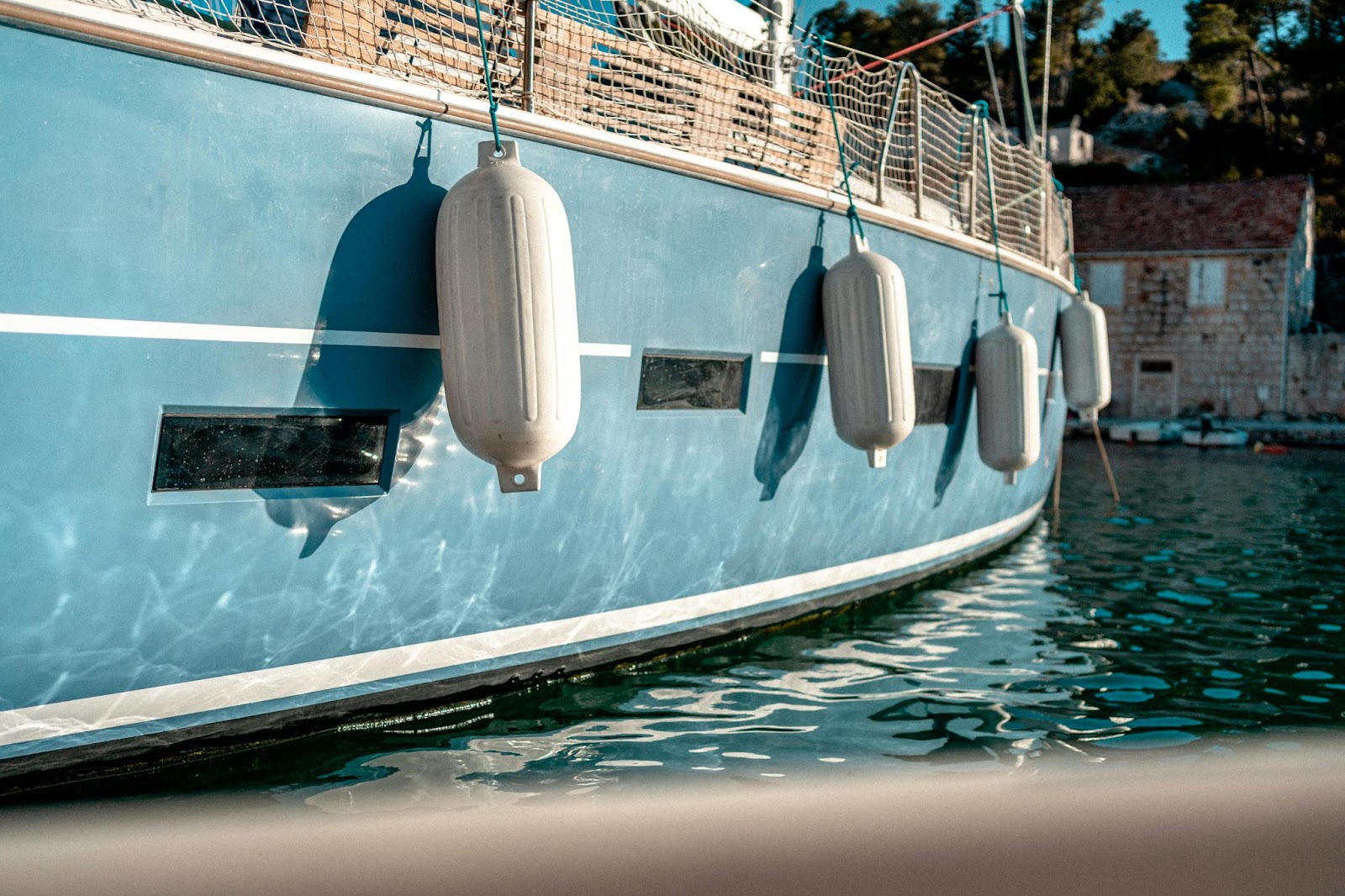 Side view of a boat featuring hanging fenders