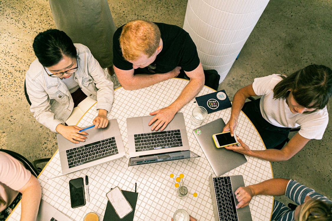 Free Top view of diverse team collaboratively working in a modern office setting. Stock Photo