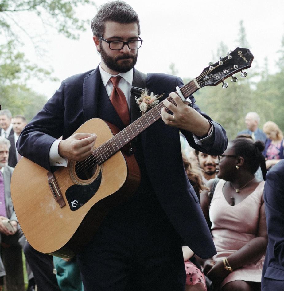 A person in a suit playing a guitar