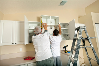 benefits of hiring local kitchen remodel contractors trade partners installing cabinets during home remodeling project custom built michigan