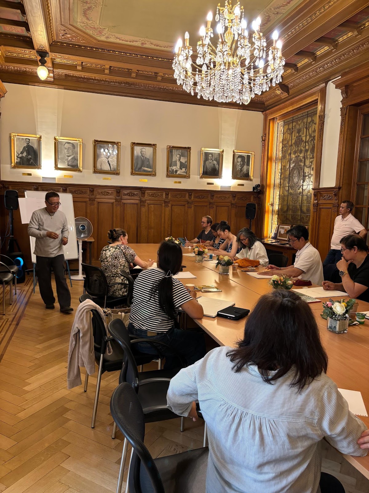 A group of people sitting around a tableAI-generated content may be incorrect.