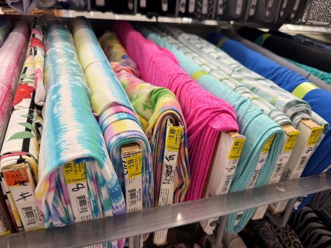A shelf with colorful fabric rolls

AI-generated content may be incorrect.