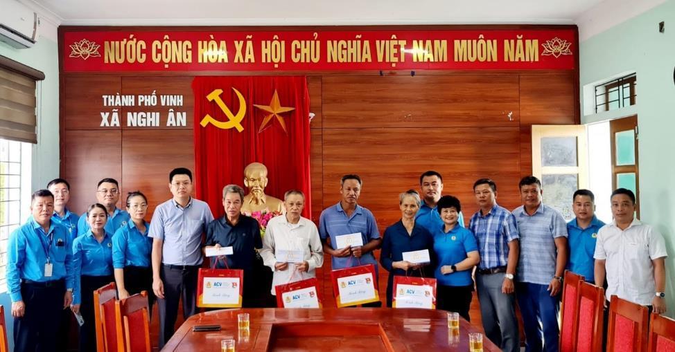 A group of people standing in front of a red curtainDescription automatically generated