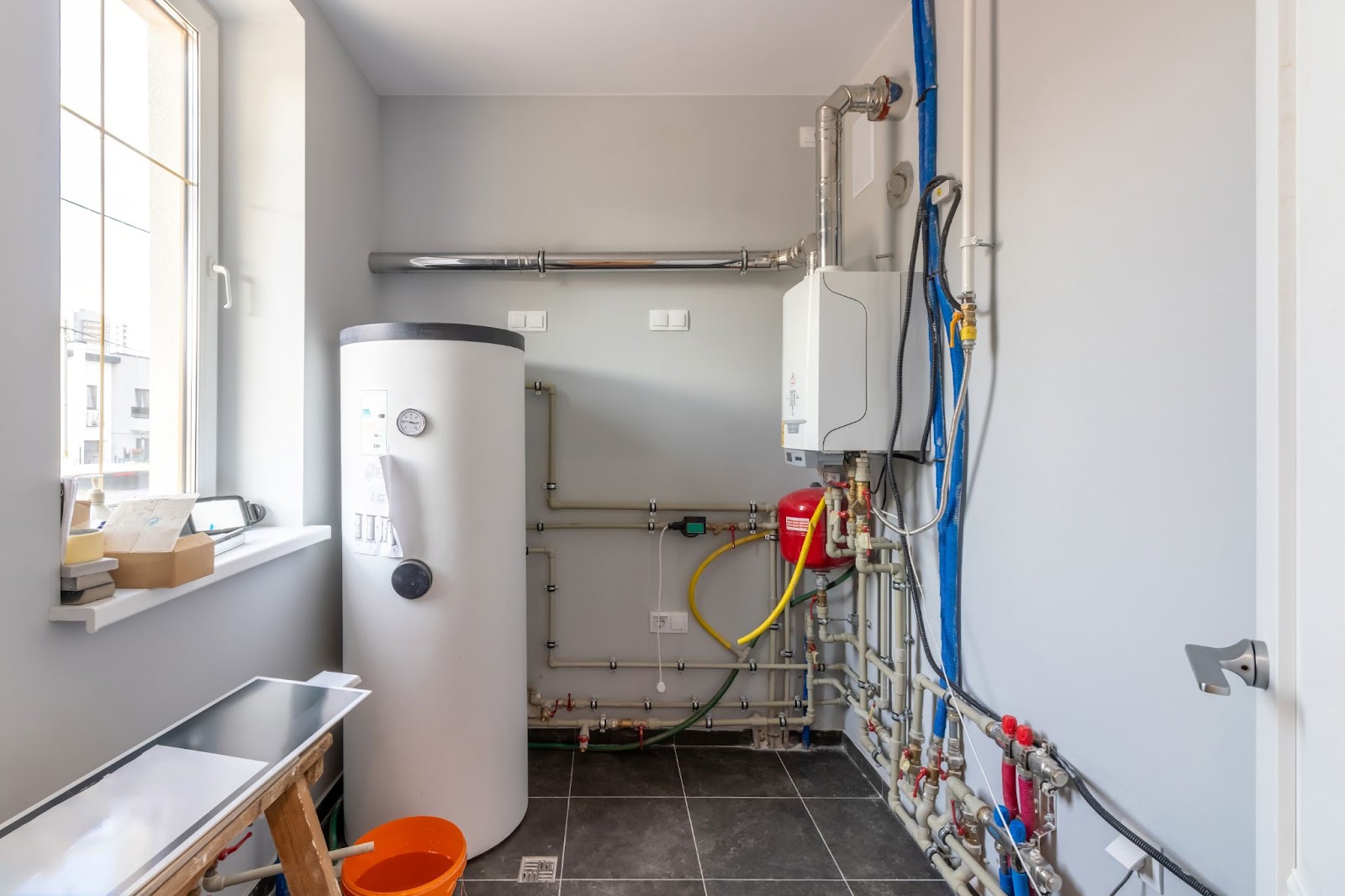 A boiler room with a boiler and hot water cylinder