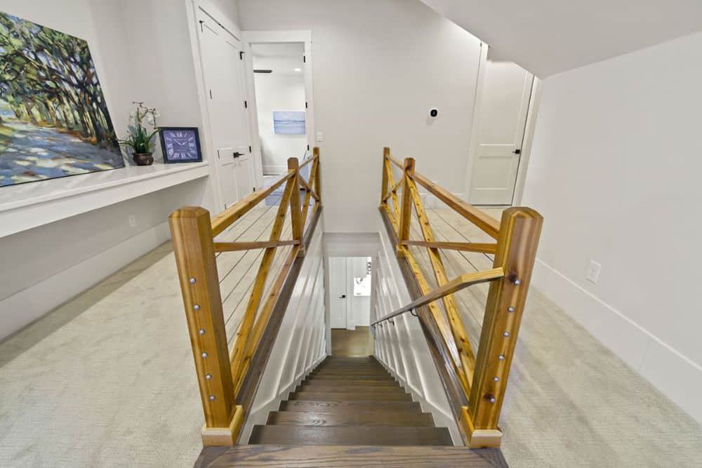 Second floor balcony with carpet flooring and wooden railings.
