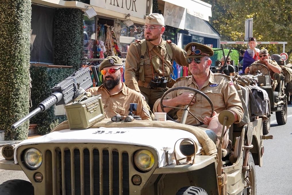 A group of men in military uniforms in a jeep

Description automatically generated