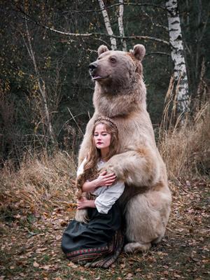 A person kneeling next to a bear

Description automatically generated with low confidence