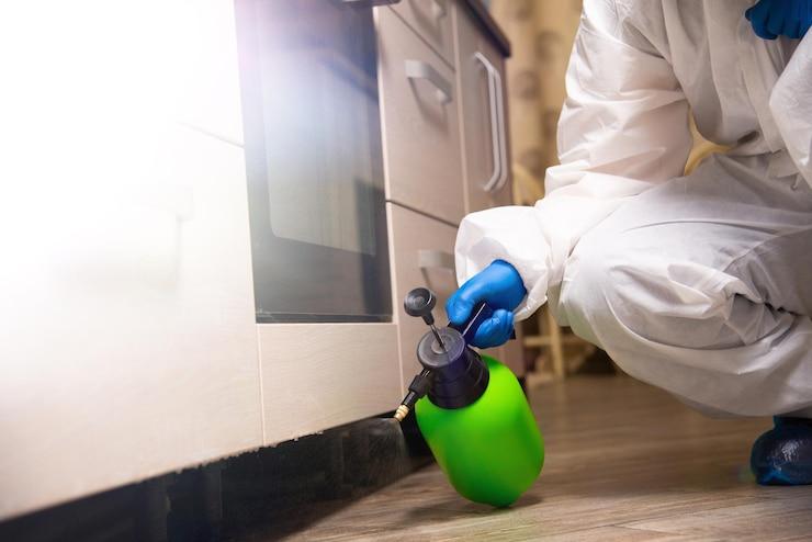 A person in a white suit spraying a green bottle

AI-generated content may be incorrect.
