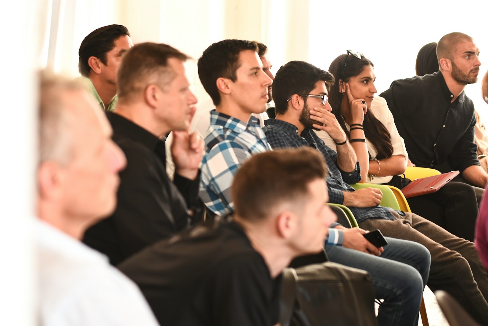 Attentive group of professionals seated in a meeting, illustrating strategies to run successful meetings.