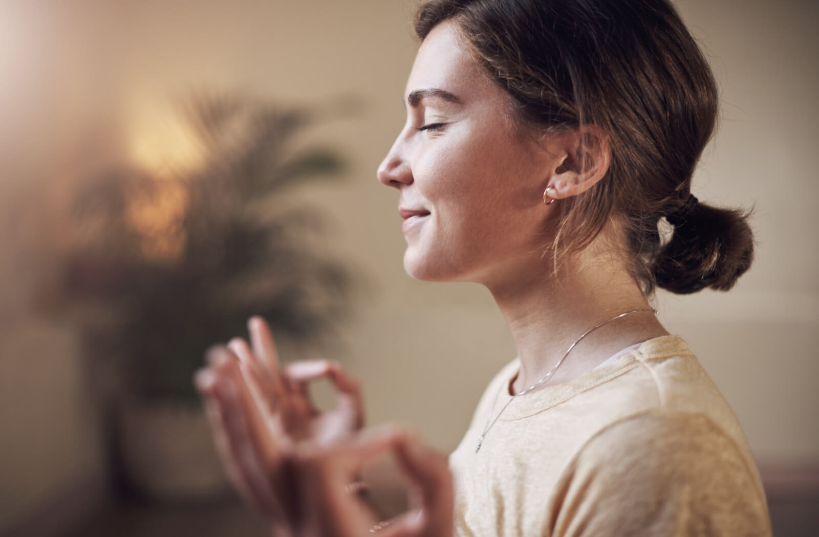 A smiling adult practices mindfulness and meditation to keep stress levels low and help prevent stress-induced dry eyes.
