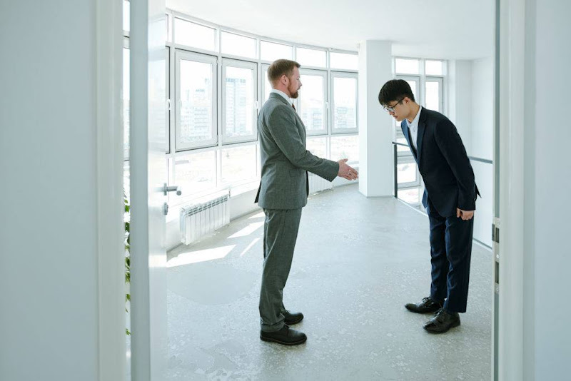 A foreigner making a greeting mistake by shaking hands instead of bowing in Japan.