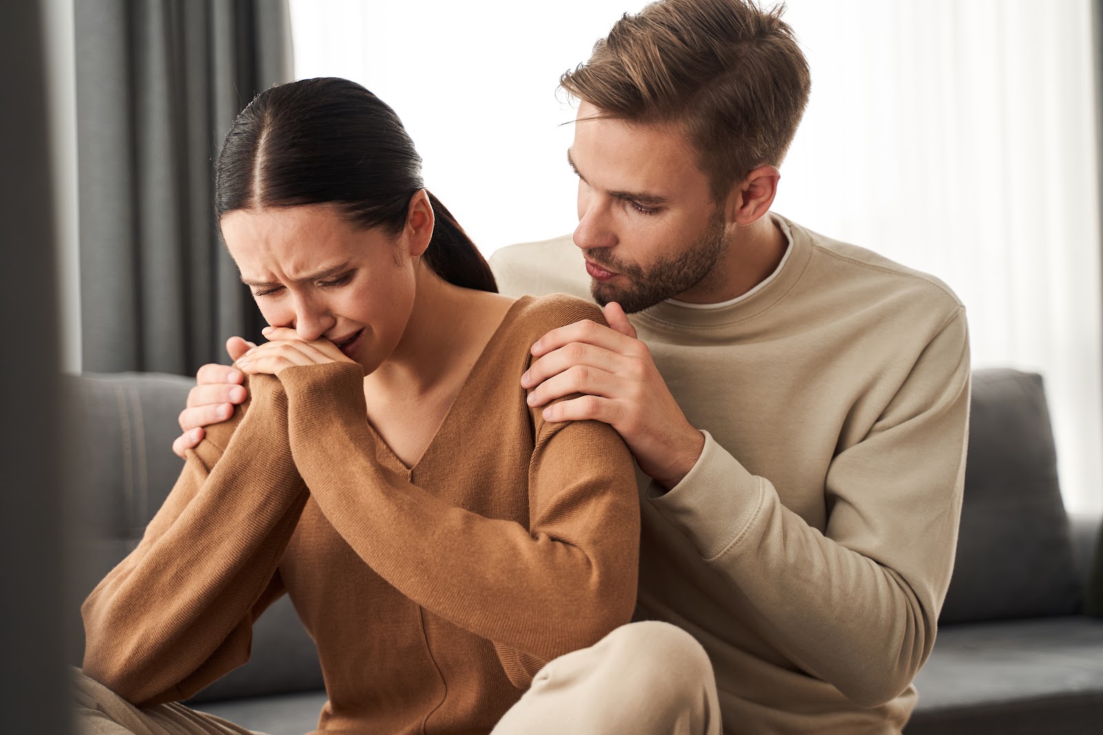 A husband calming his crying wife | Source: Shutterstock