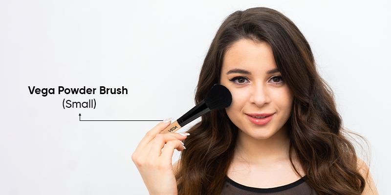 A person holding a brush to her face

Description automatically generated