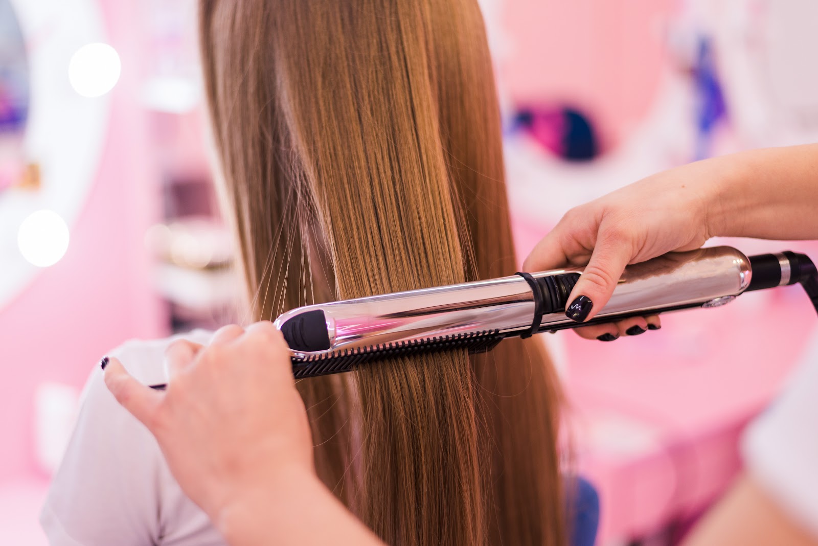 Hairdresser straightening the hair of a client