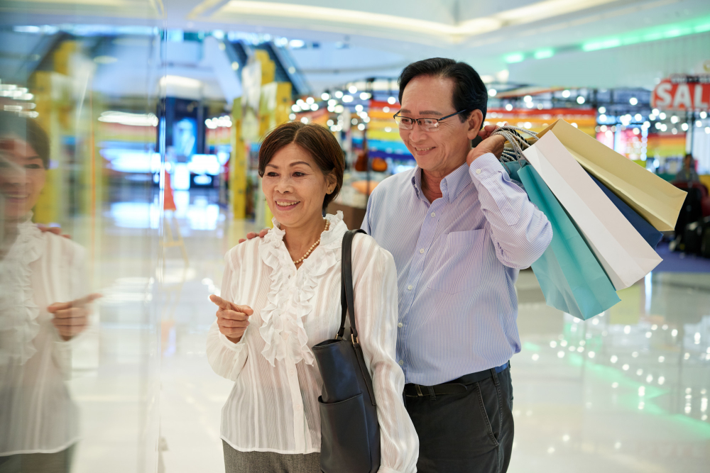 Elderly couple shopping with bags, showing senior consumer behavior.