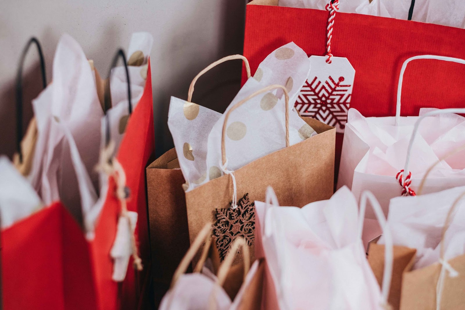 A collection of festive holiday shopping bags, representing the heightened risk of common holiday scams during the shopping season