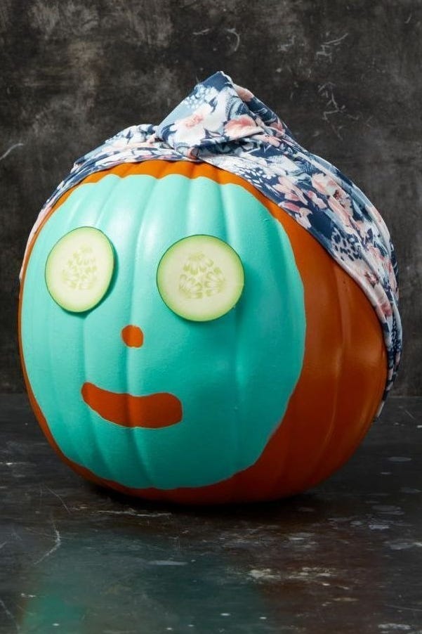 diy halloween decorations, orange pumpkin with cucumbers for eyes and a mask