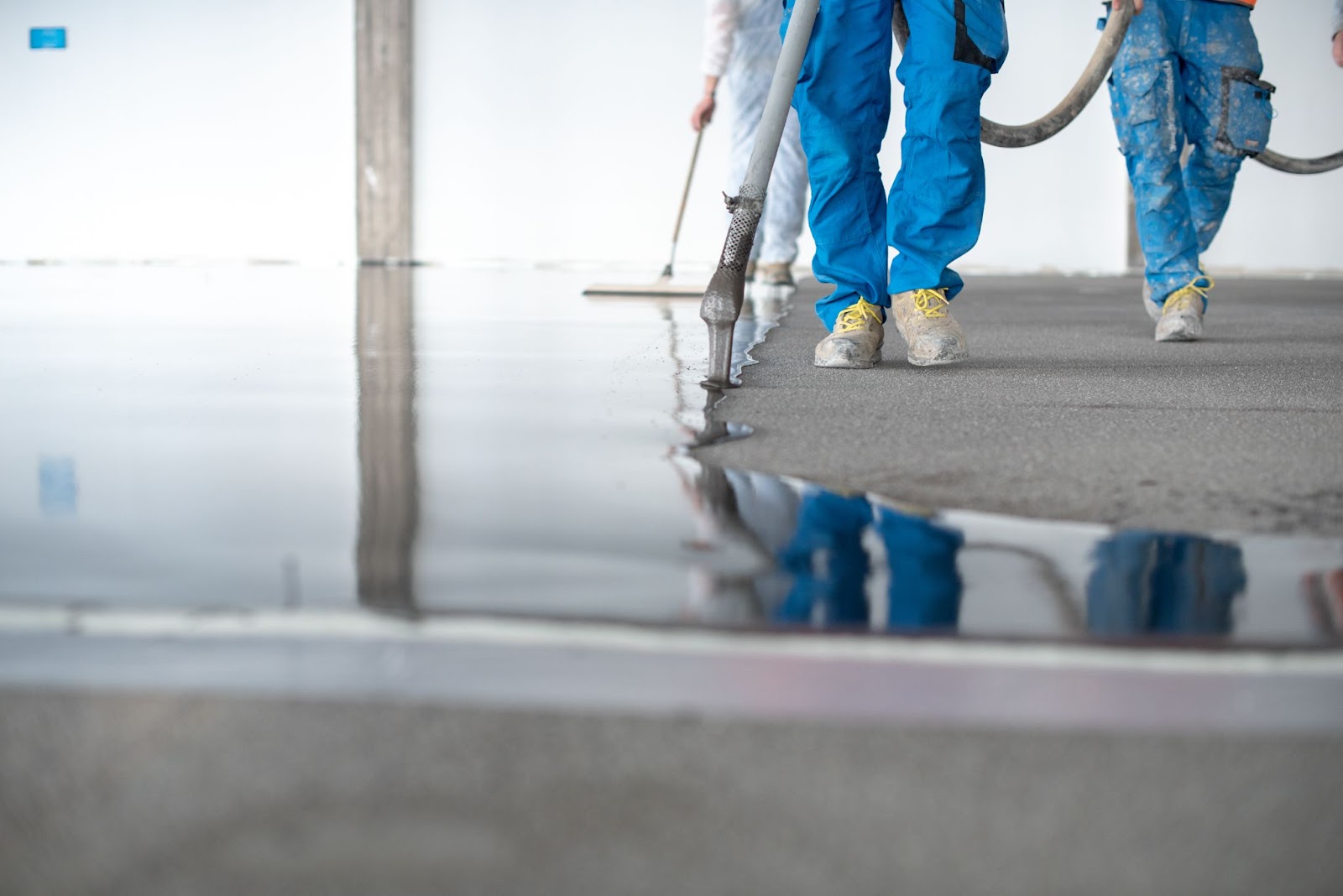 Concrete workers pouring a concrete floor. 