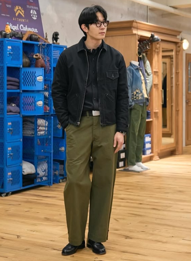 Pria tampil ala Korean Style dengan kemeja hitam, jaket hitam, dan celana olive.