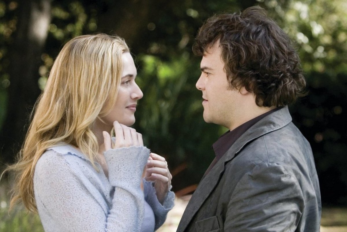 Jack Black y Kate Winslet en un jardín conversando románticamente, ella con suéter claro y él con chaqueta oscura.