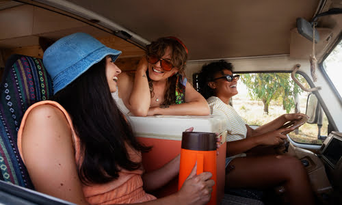 three ladies on on a trip, in a car smiling