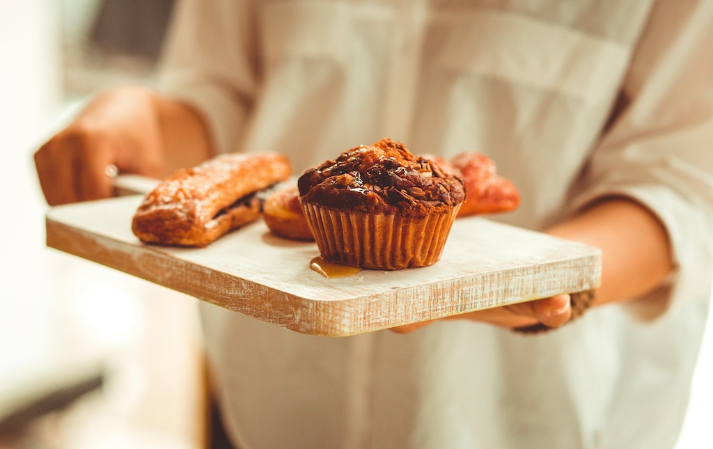 muffin and pastries displayed on a wooden board