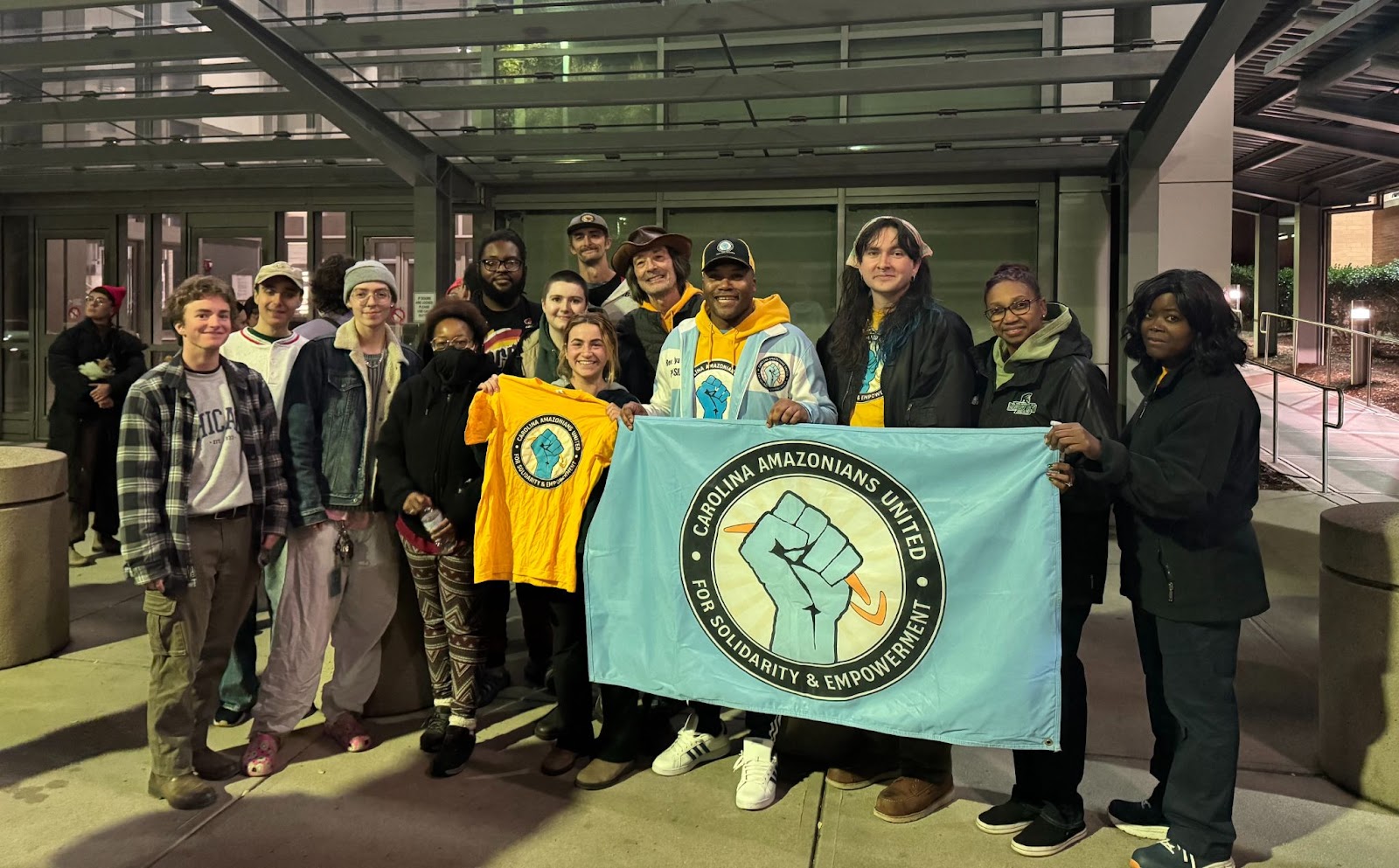 Amazon workers pose with their union banner