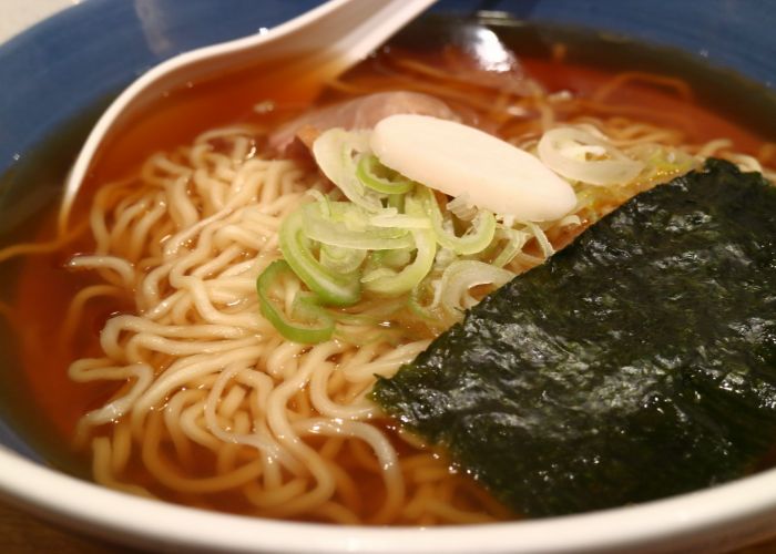 A bowl of shoyu (soy sauce) ramen topped with seaweed and green onions