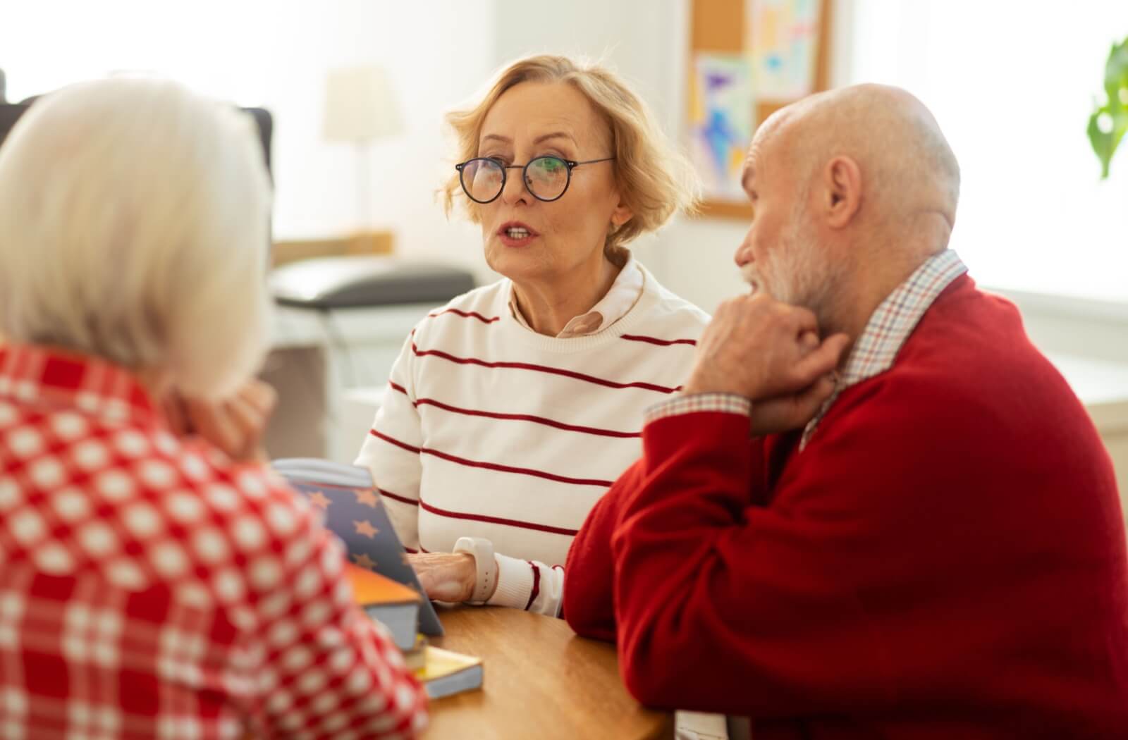 A book club in an assisted living community has a lively discussion about their recent book.