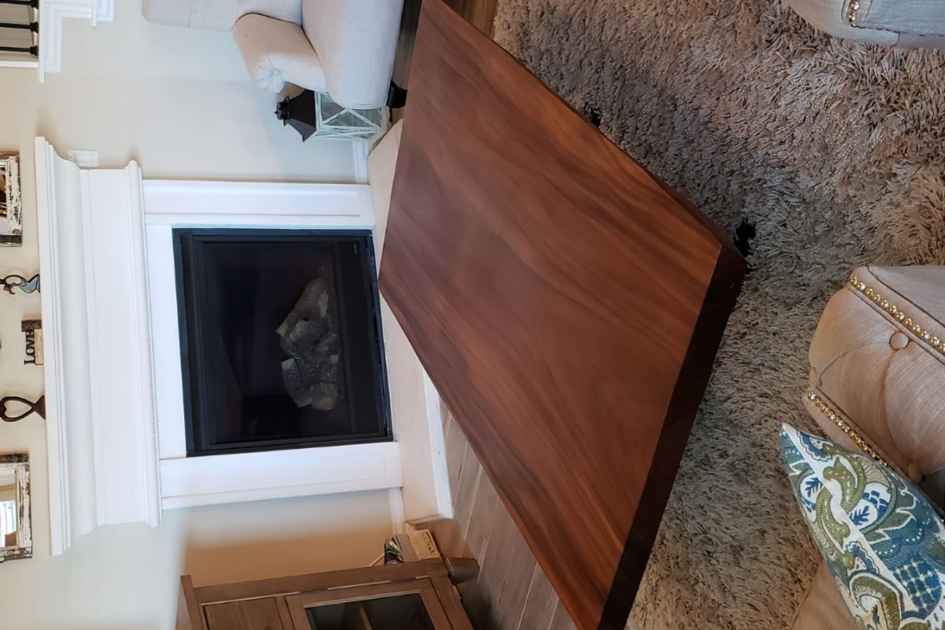 live edge wood table in front of a fireplace