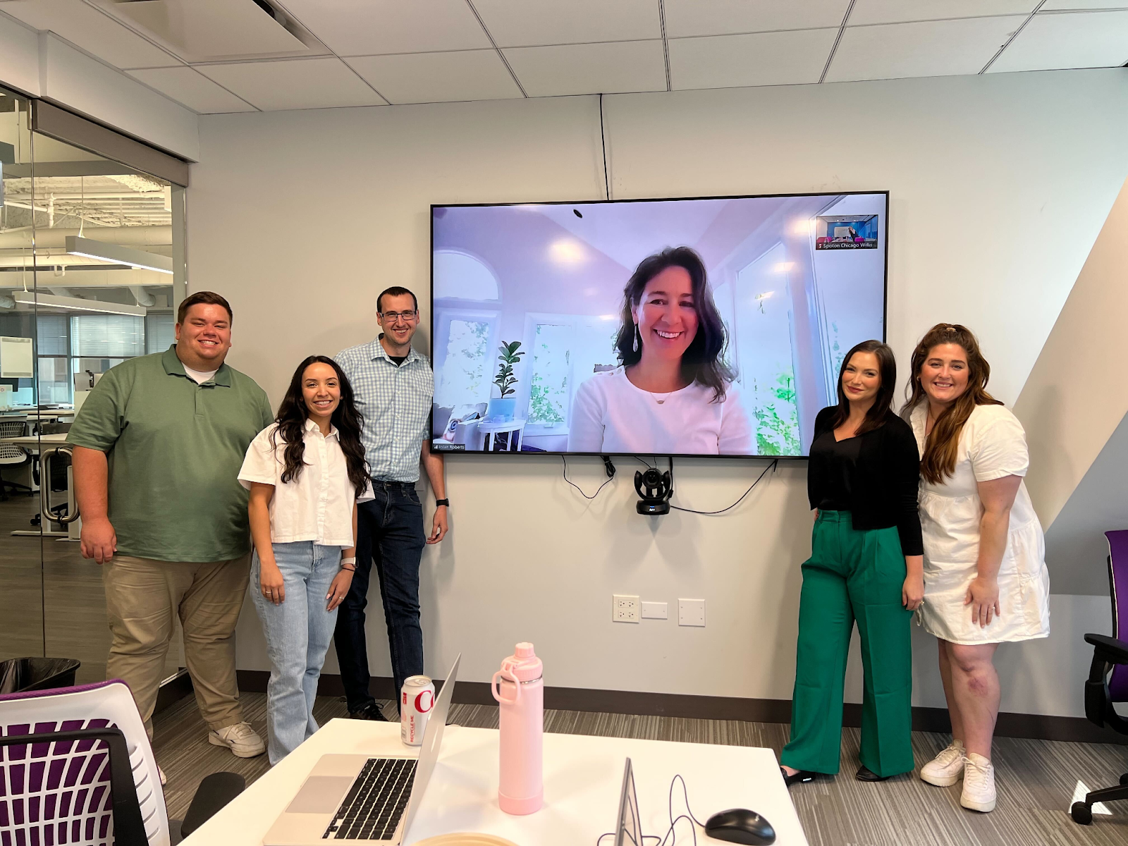 SpotOn employees posing with an employee on a Zoom meeting.