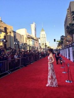 Korean actress Kim Soo Hyun on red and white dress standing on a red carpet facing crowd