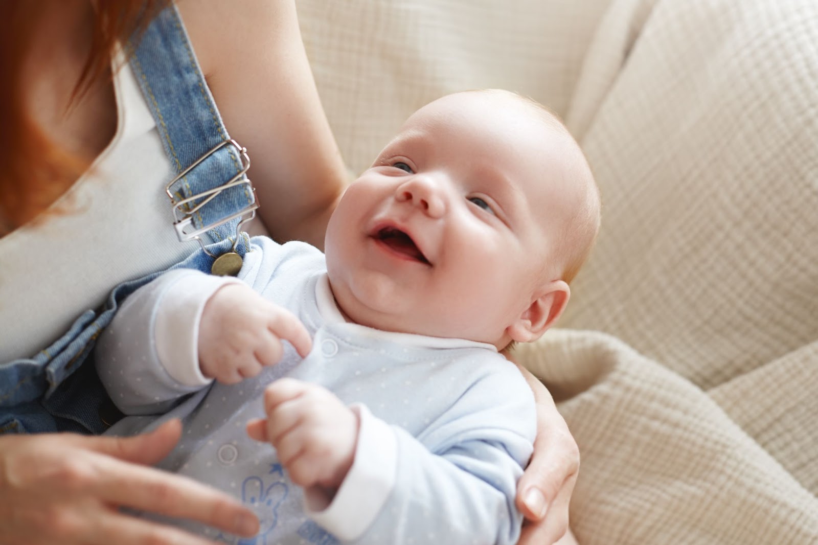 A laughing baby is seen looking at her mother.