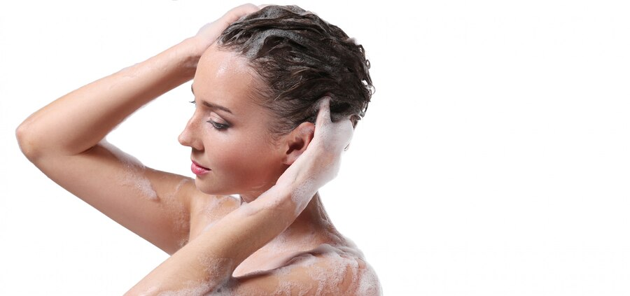 Woman showering with shampoo on head