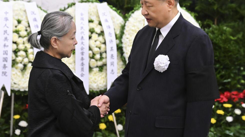 在新华社发布的这张照片中，2025 年 6 月 8 日星期日，在北京八宝山革命公墓举行的遗体告别仪式上，中国国家主席习近平（右）与中央军委原副主席许其亮的家属握手，表示深切哀悼。