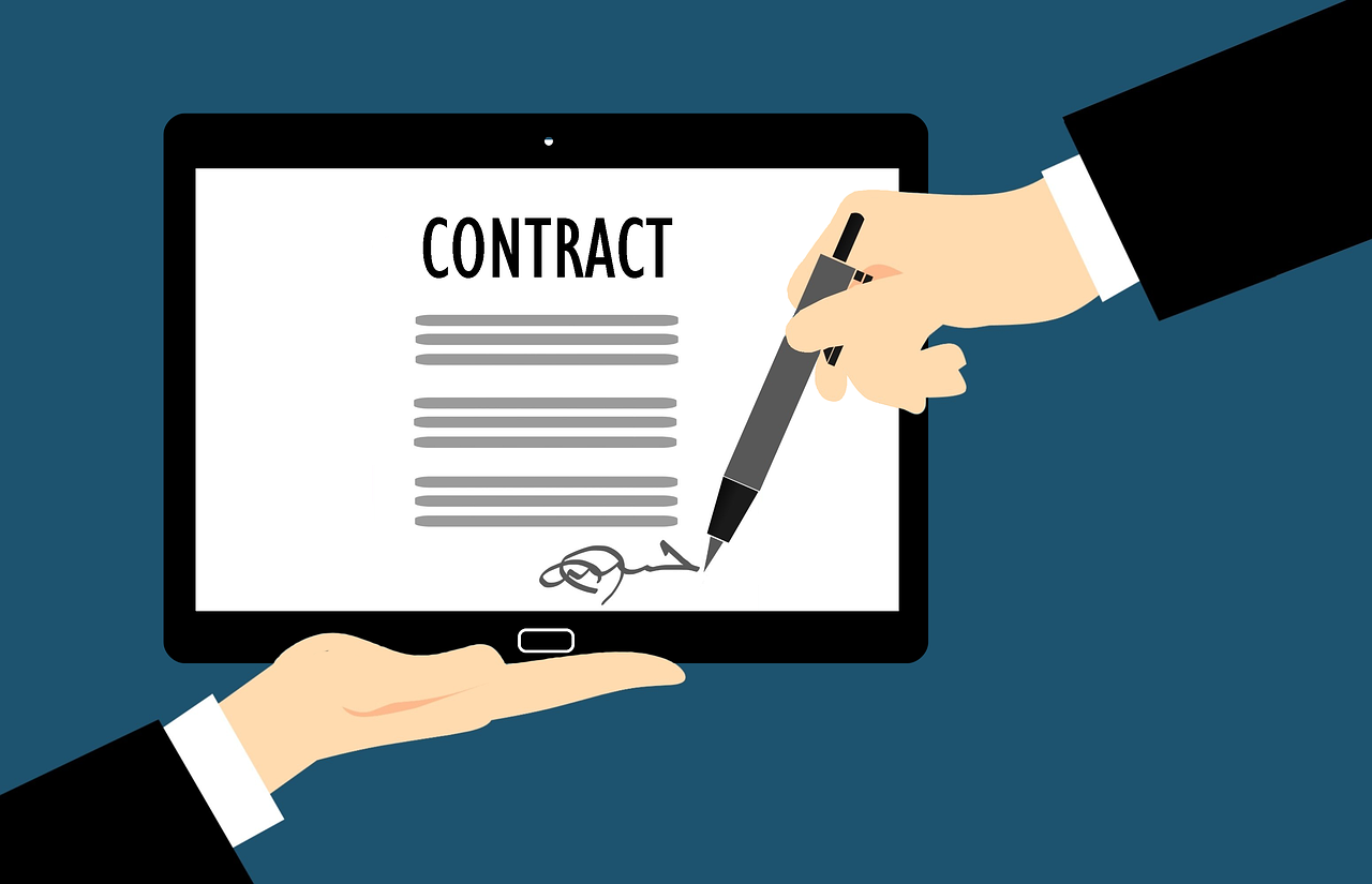 A digital image of a tablet displaying a contract being signed electronically by one person, while another person holds the tablet.