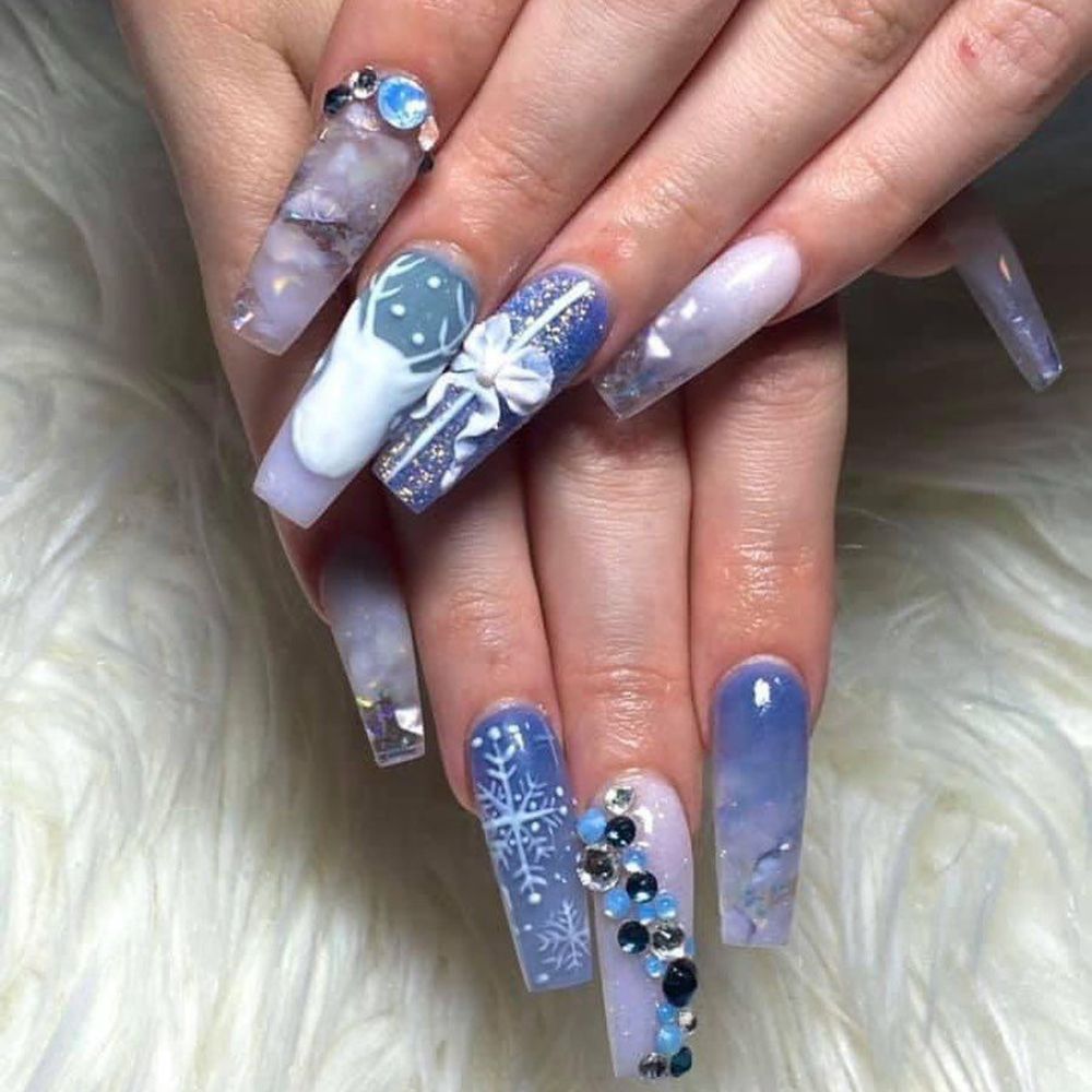 Close up of hands with blue winter nails having stylish art