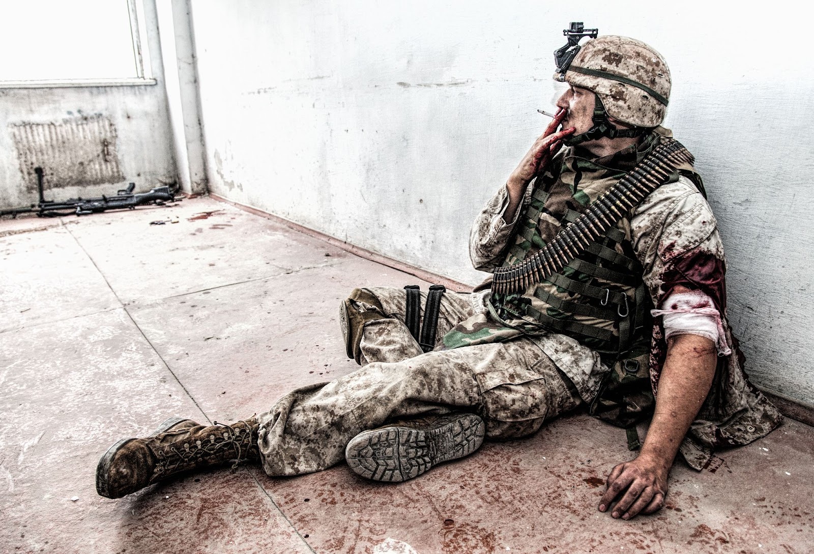 soldier smoking while sitting on a floor