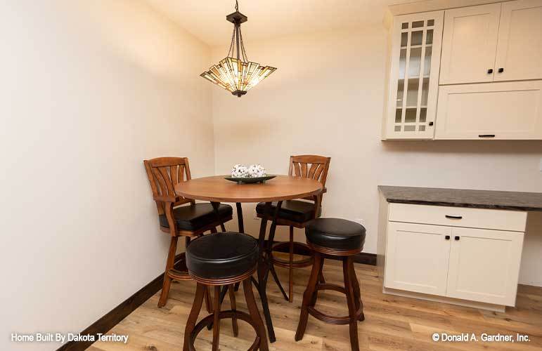 A stylish glass pendant illuminates the round dining set.