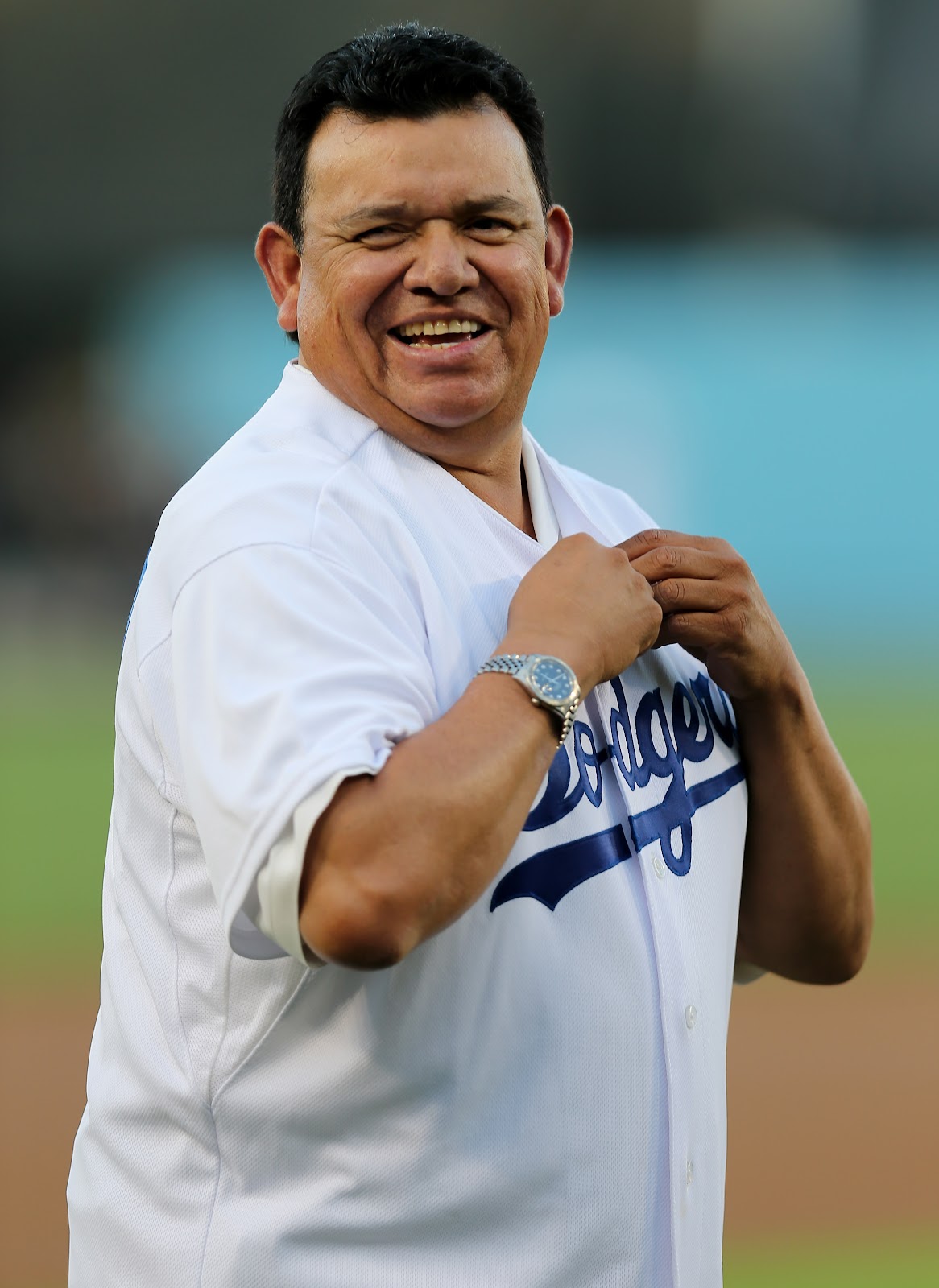 Fernando Valenzuela laughs as he puts on a Dodger jersey for pre-game ceremonies before the game between the Colorado Rockies and the Los Angeles Dodgers at Dodger Stadium in Los Angeles, California, on September 29, 2012 | Source: Getty Images