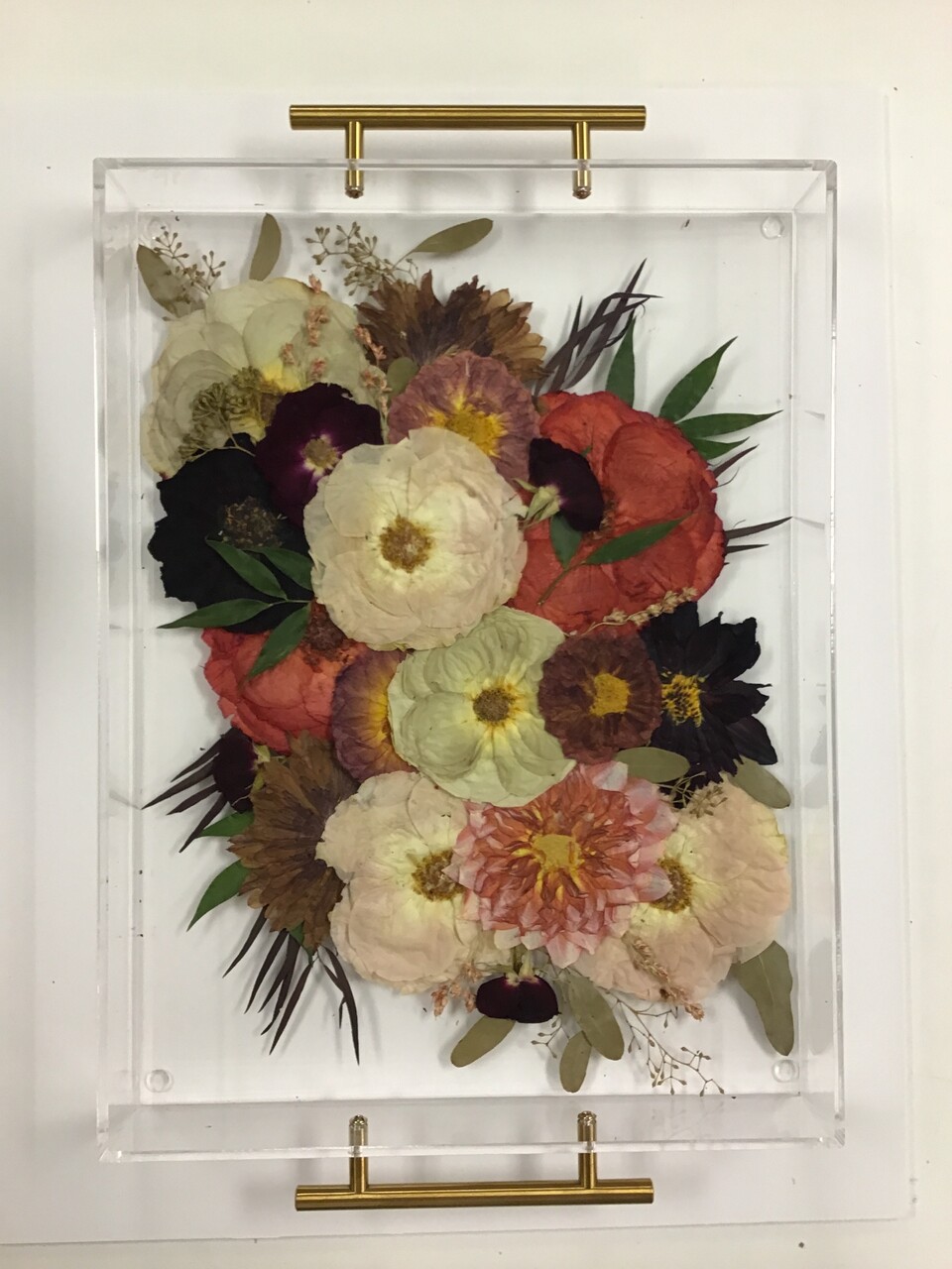 A pressed flower serving tray on a table