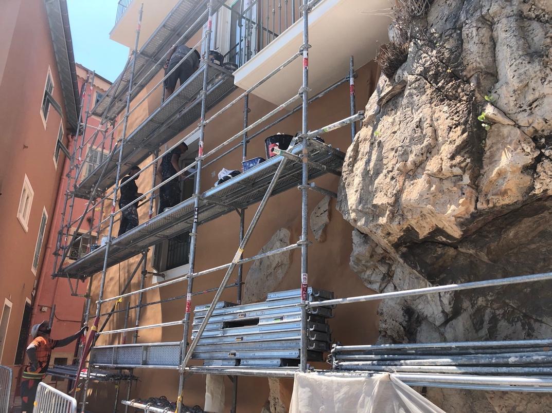 A group of people on scaffolding outside of a building

Description automatically generated