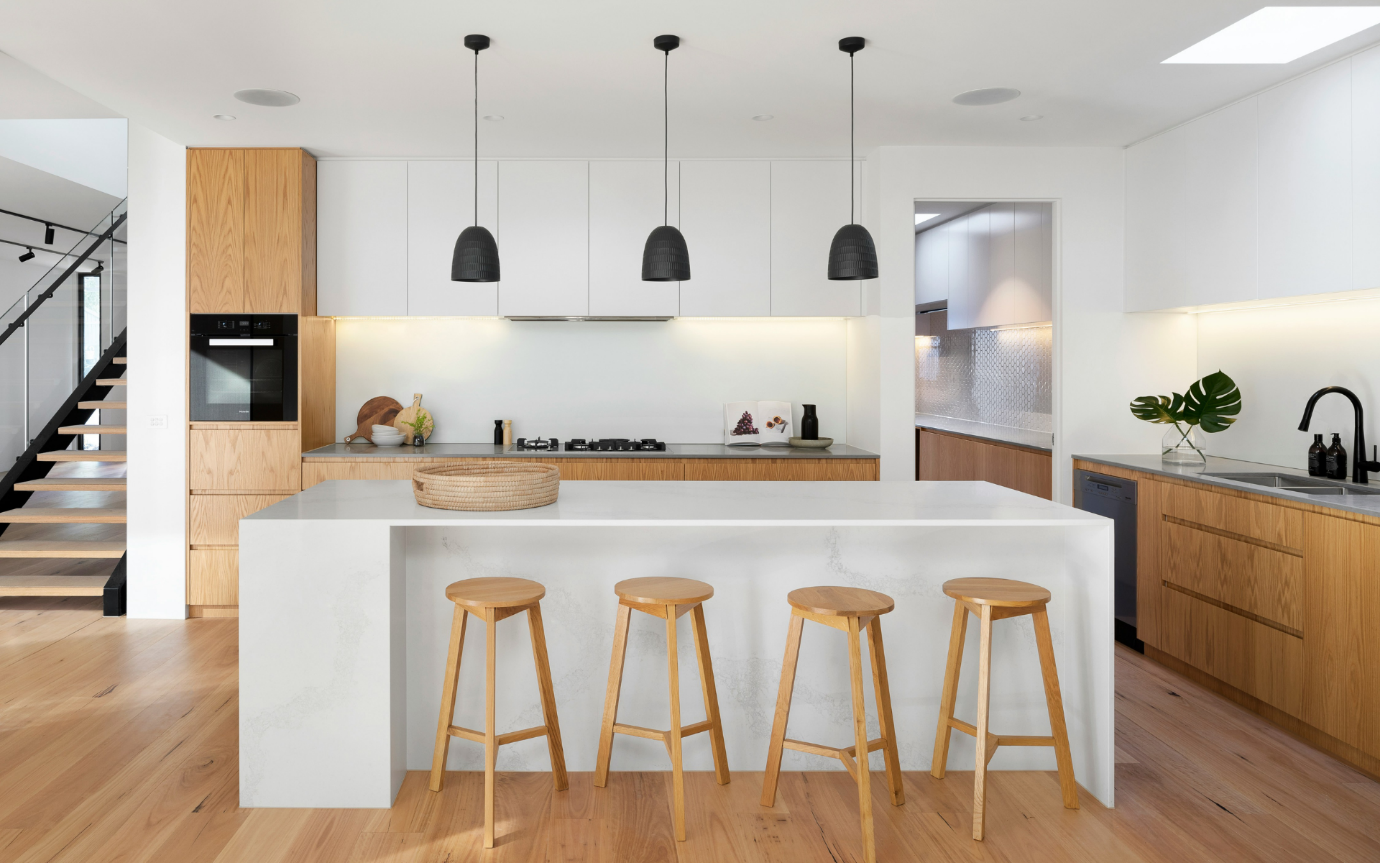 A kitchen with a bar stools and a counterDescription automatically generated