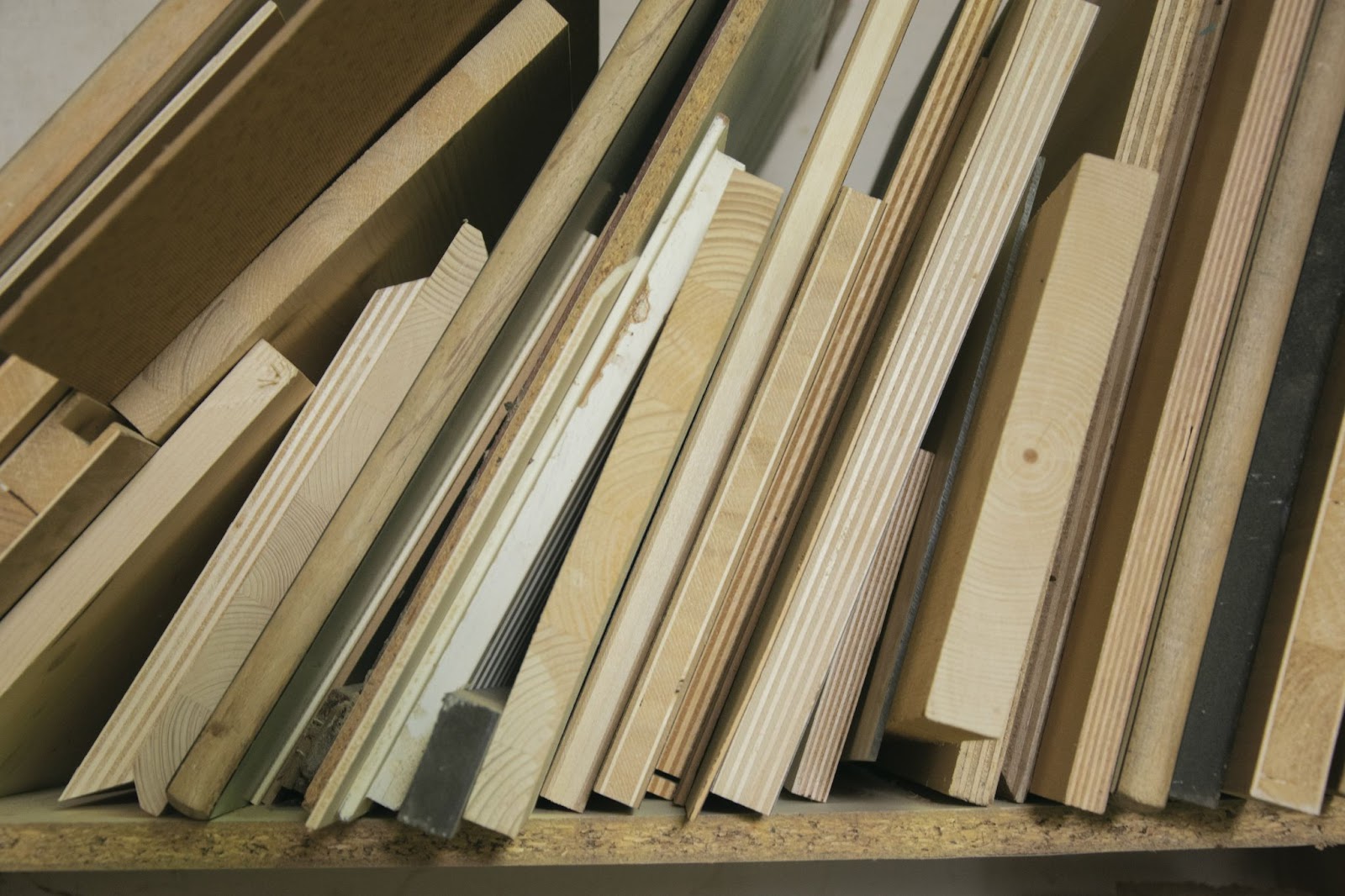 Wood offcuts stacked vertically on a shelf.