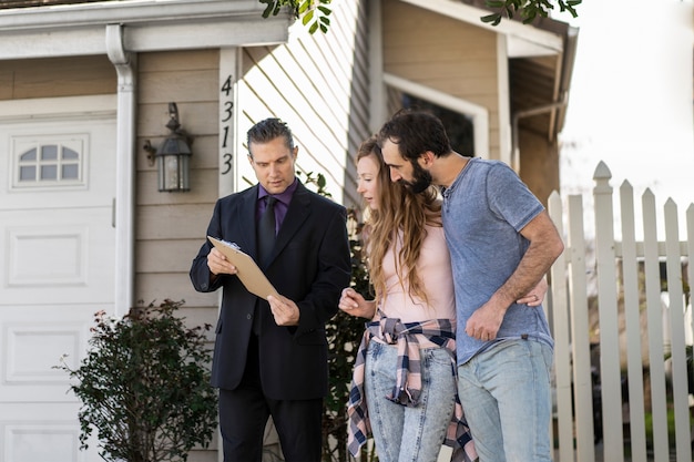 Happy family in front of a house with insurance documents