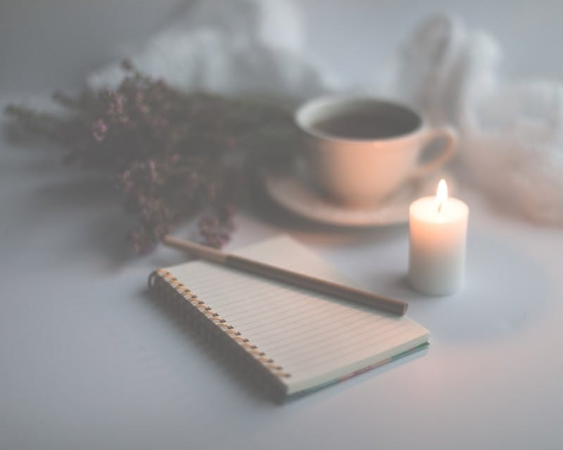 image of journal, candle, tea to represent self-relfection