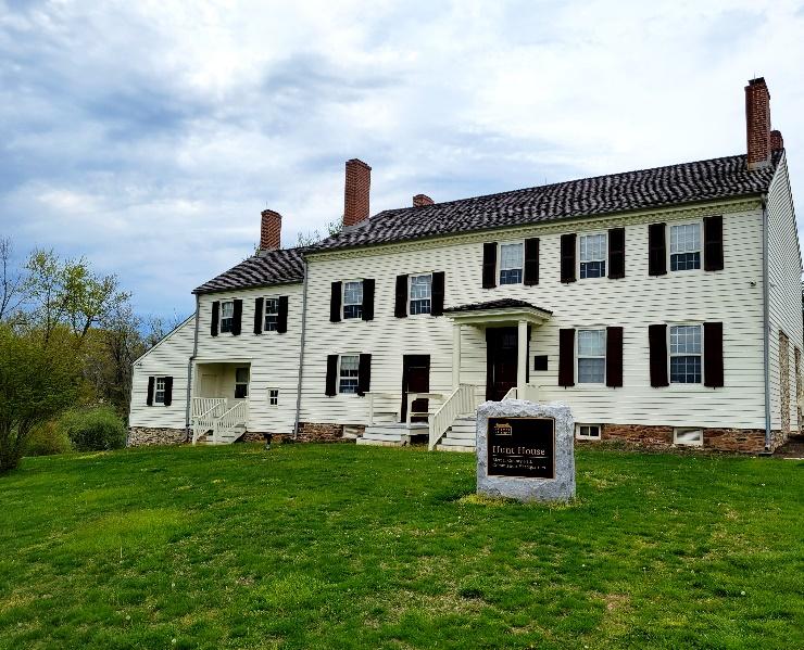 A large white house with a sign in front of it

Description automatically generated