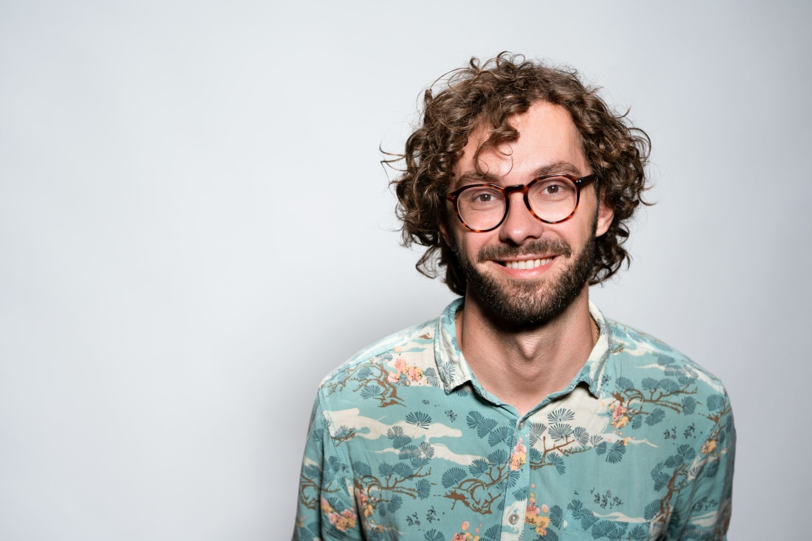 The approachable headshot pose against a solid background