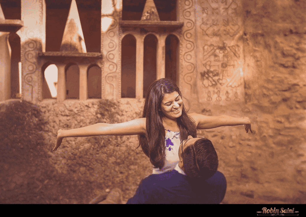 Pre wedding shoot of a couple in Rock Garden, groom lifting bride both are smiling joyfully.