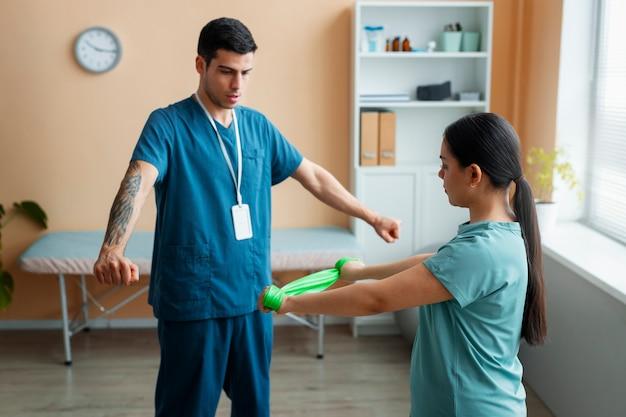 Doctor helping patient during rehabilitation